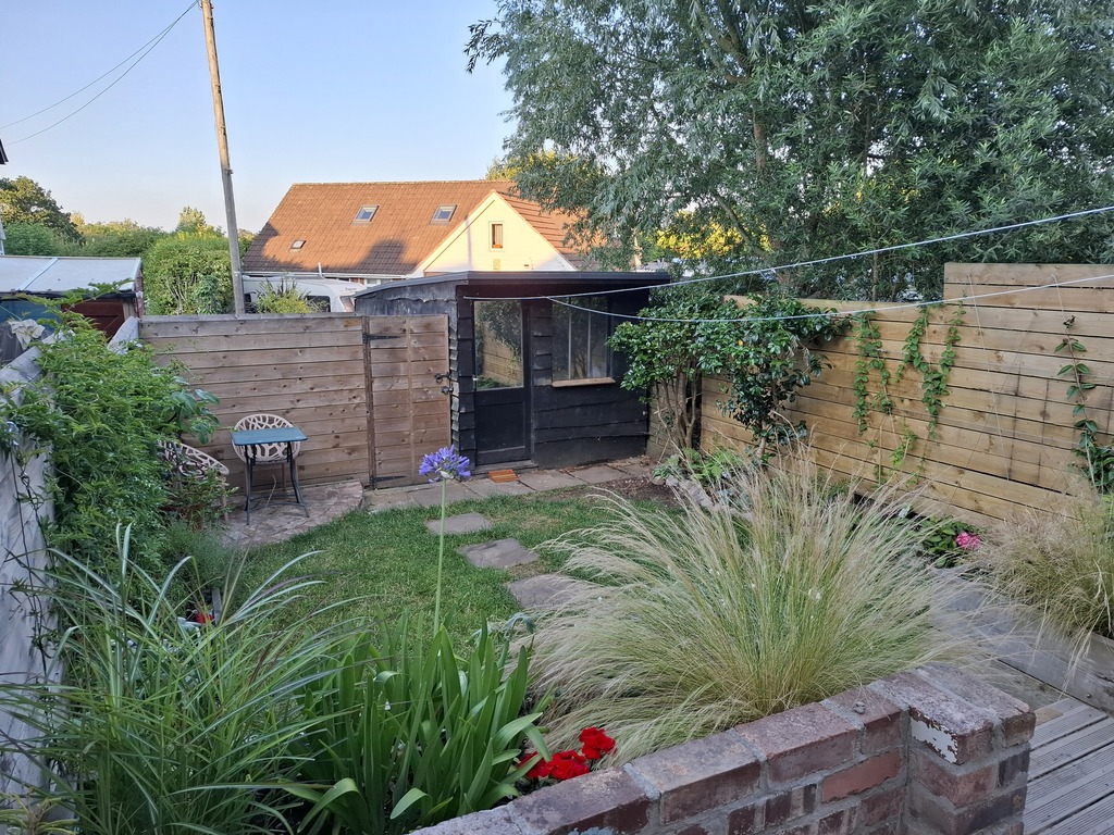 Back garden in summer, and door to outside parking space.
