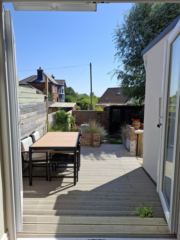 Deck off the kitchen door, leading to the garden. 