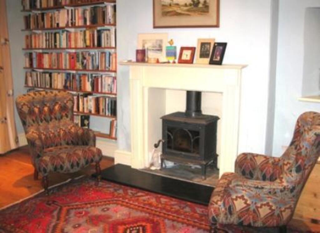 piano room with wood burning fire