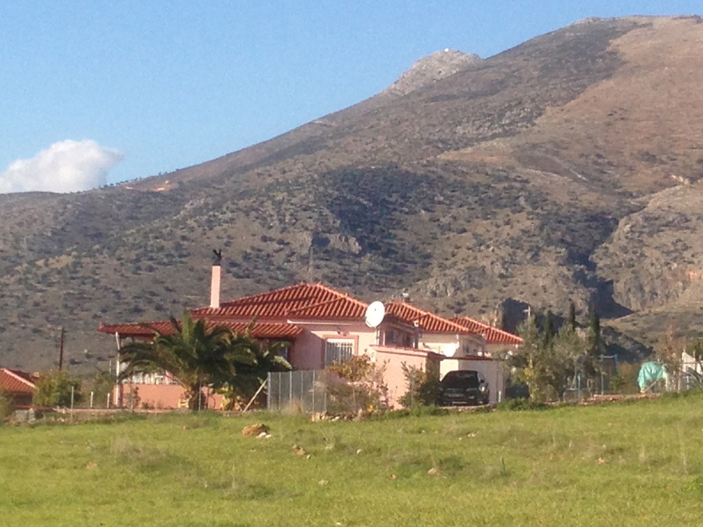 The house is surrounded by mountains, olive-and orange trees.

