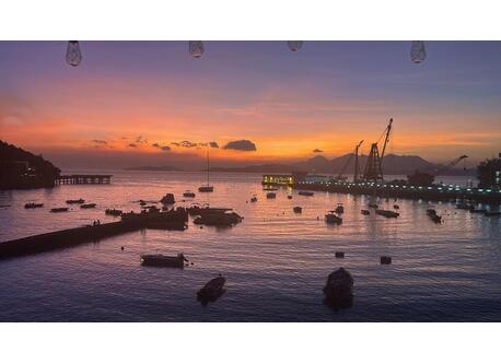 Sunset from our rooftop. Ferry pier to Central or Aberdeen is to the right.