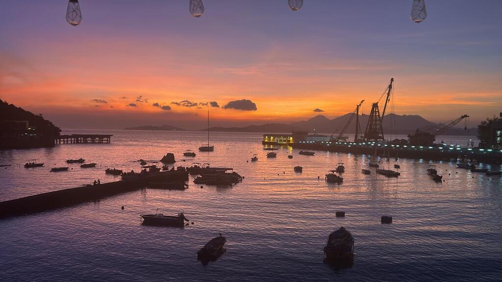 Sunset from our rooftop. Ferry pier to Central or Aberdeen is to the right.