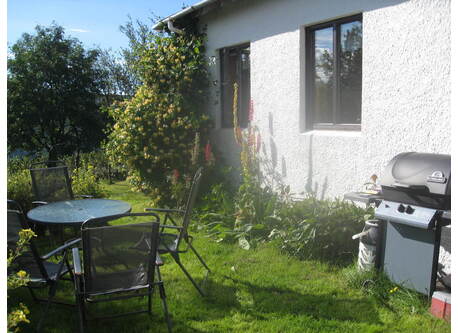 The barbecue and sitting area behind the house. 
