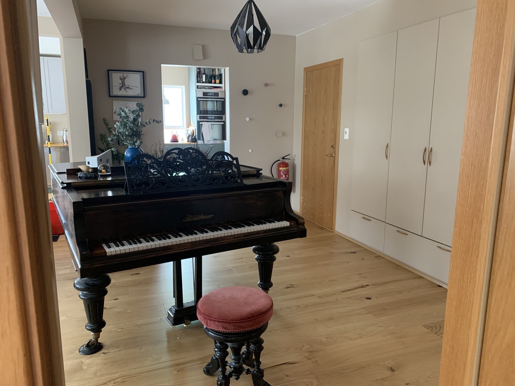 The hallway with large closets and a grand piano.