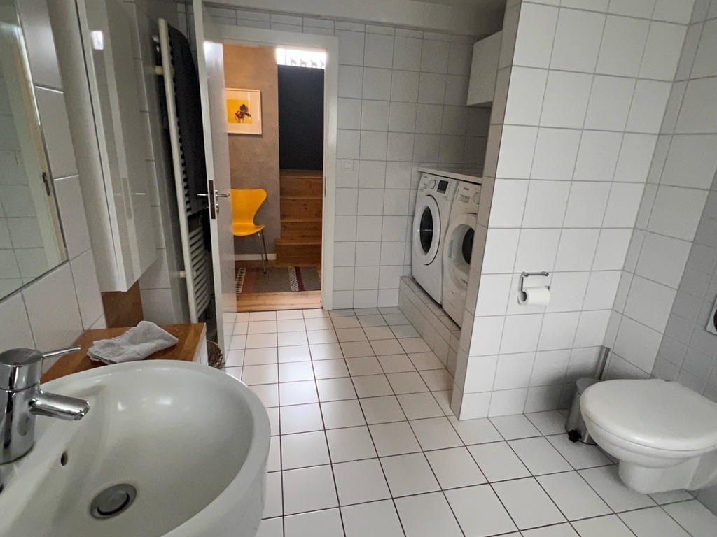 A washing machine and a dryer are located in the bathroom.