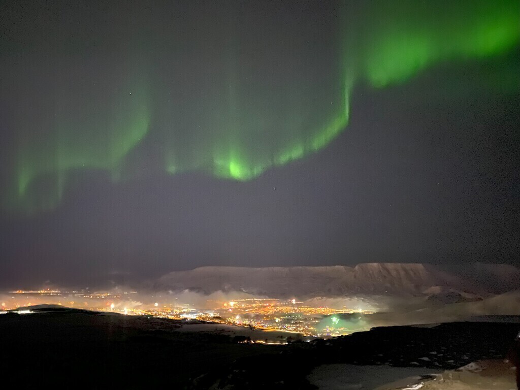 Taken from the top of Hafrahlíð on new years eve. This is Mt Esjan with the northern lighst, no filter.