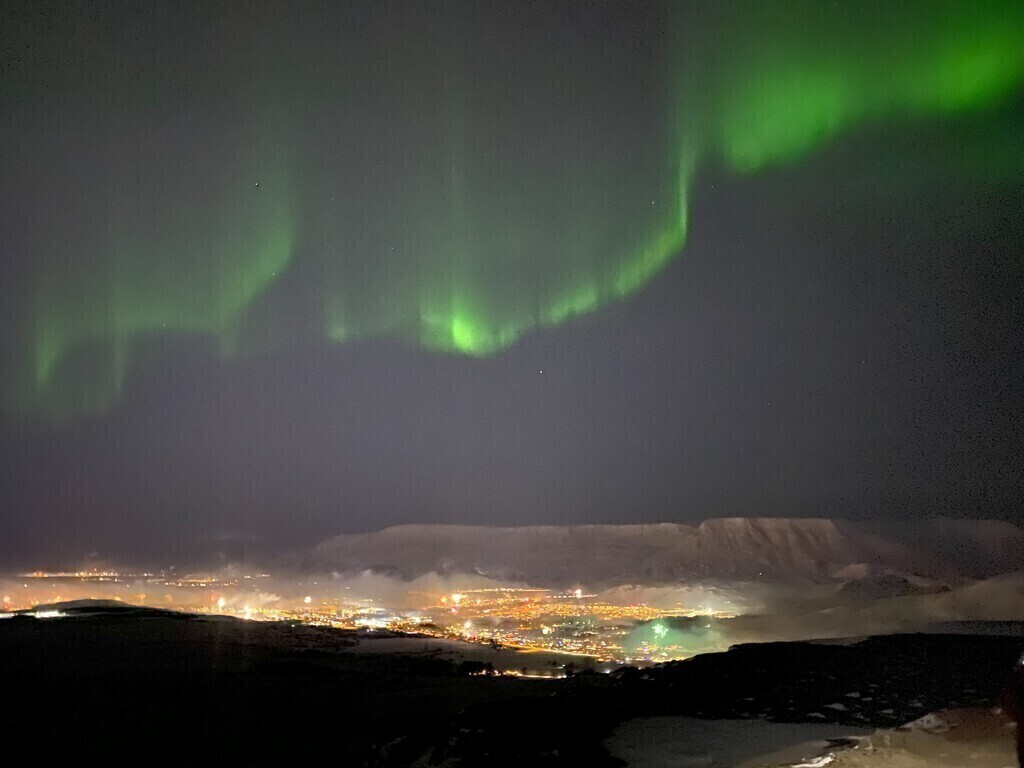 Taken from the top of Hafrahlíð on new years eve. This is Mt Esjan with the northern lighst, no filter.