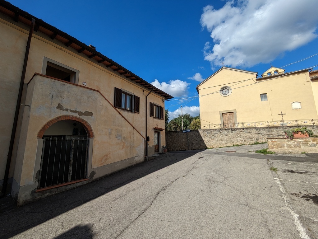 The house with the church above the small square, with parking.