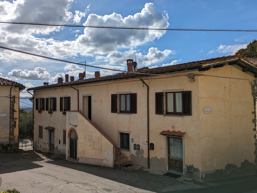 The house, on the first floor, with the shutters open
