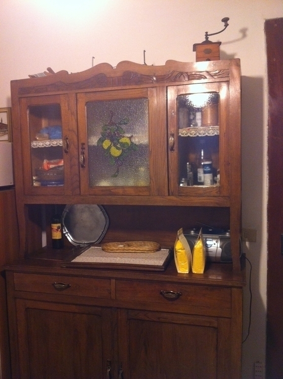 credenza in cucina con tazze, zucchero, caffè, piatti e pentole