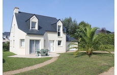 Front view of the house, oriented to south. Garden around, and garage on the right.