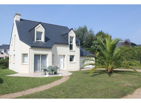 Front view of the house, oriented to south. Garden around, and garage on the right.