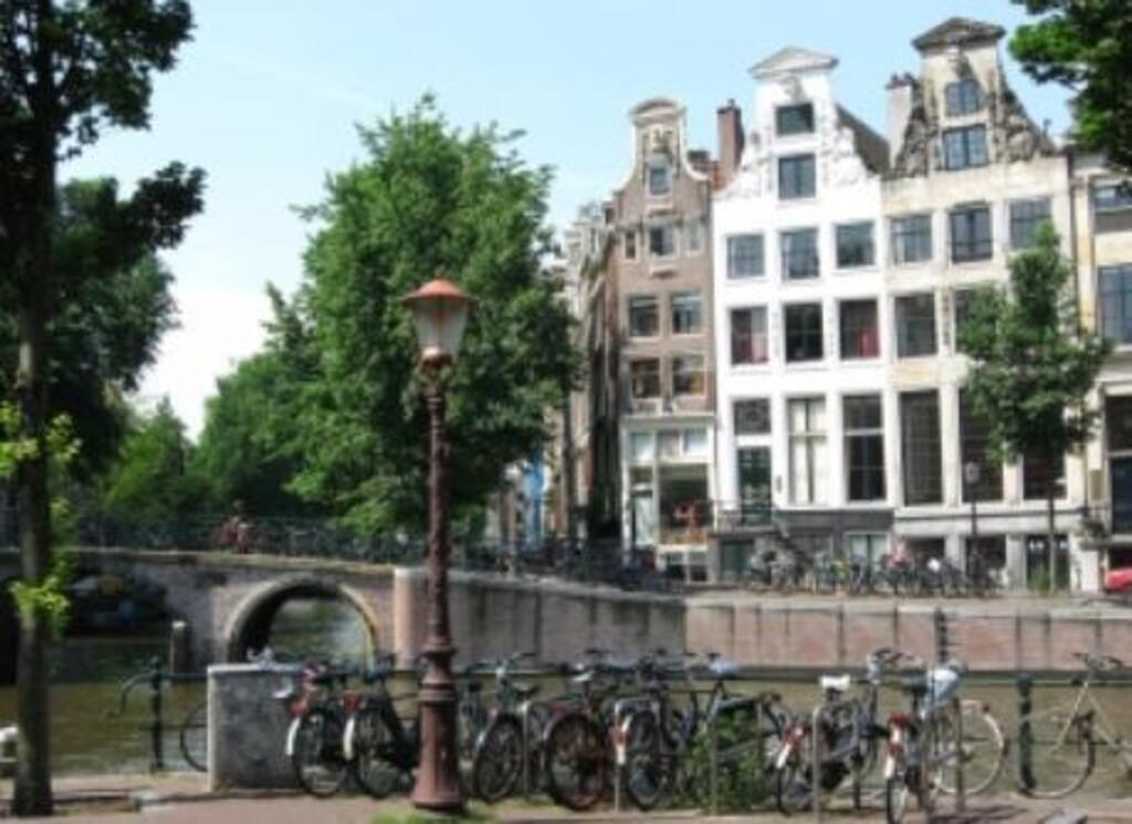 Historical city center with beautiful canals, canal houses, bridges, house boats and trees.