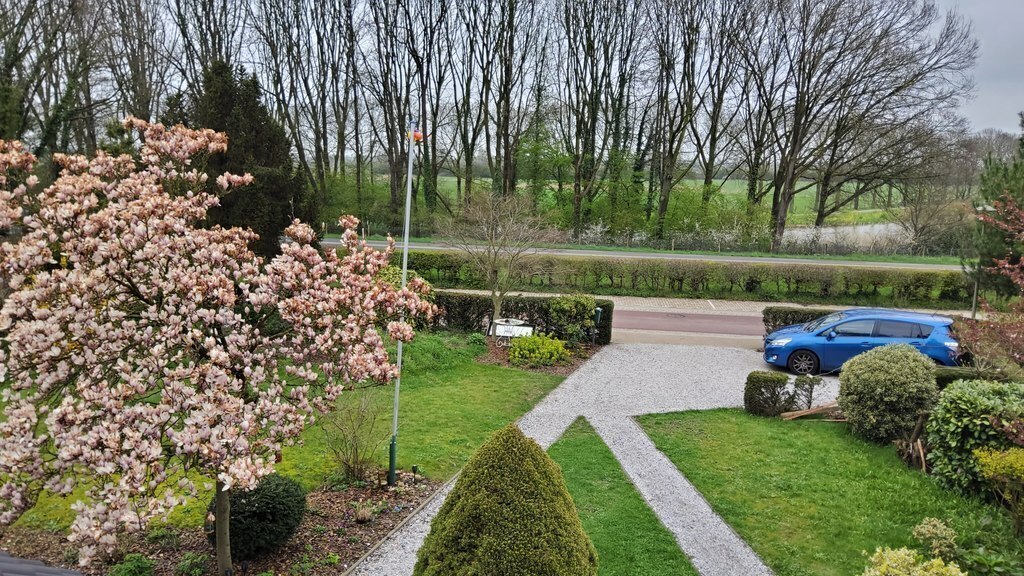 View from first floor over the front garden (incl private parking) and free view over the 'Ooijpolder' landscape. 