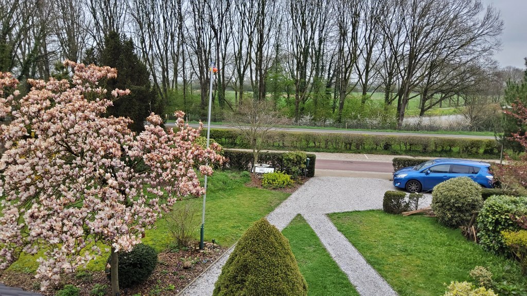 View from first floor over the front garden (incl private parking) and free view over the 'Ooijpolder' landscape. 