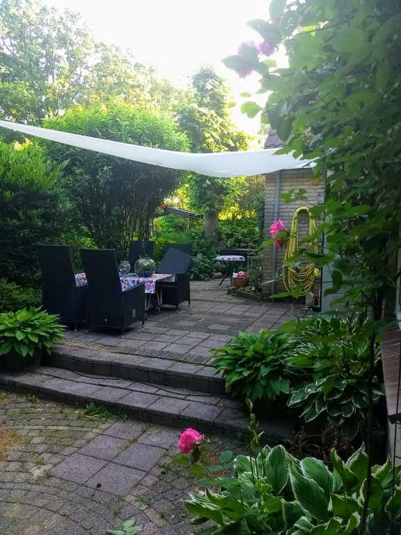 Terras met zonnescherm, beschut zitten.