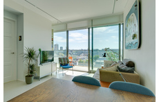 The living area opening up to the balcony, with view over the water of IJ river and the city of Amsterdam.