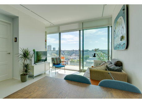 The living area opening up to the balcony, with view over the water of IJ river and the city of Amsterdam.