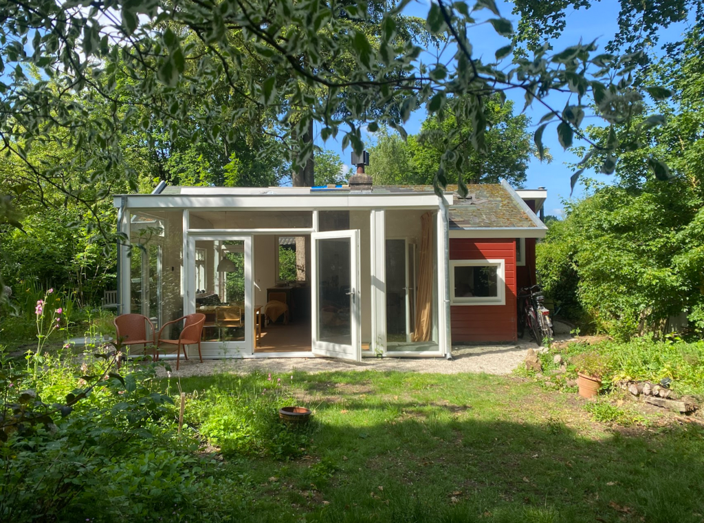 Het huisje gezien vanaf de bosrand. 