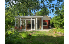 Het huisje gezien vanaf de bosrand. 