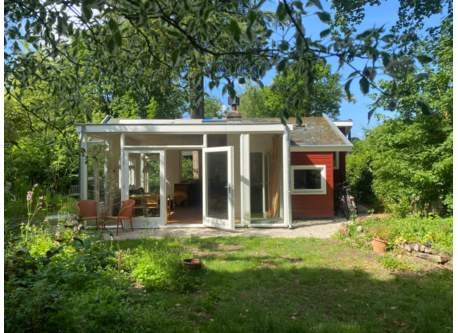 Het huisje gezien vanaf de bosrand. 