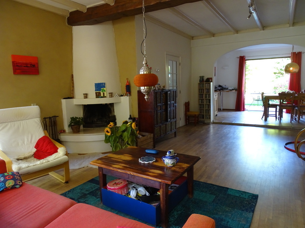 Living room with couch and lazy chairs, fire place and tv hidden in cabinet
