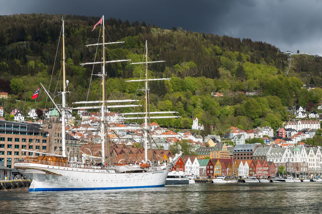 Bryggen and the ship Statsraad Lehmkuhl. Fløibanen on the hillside behind