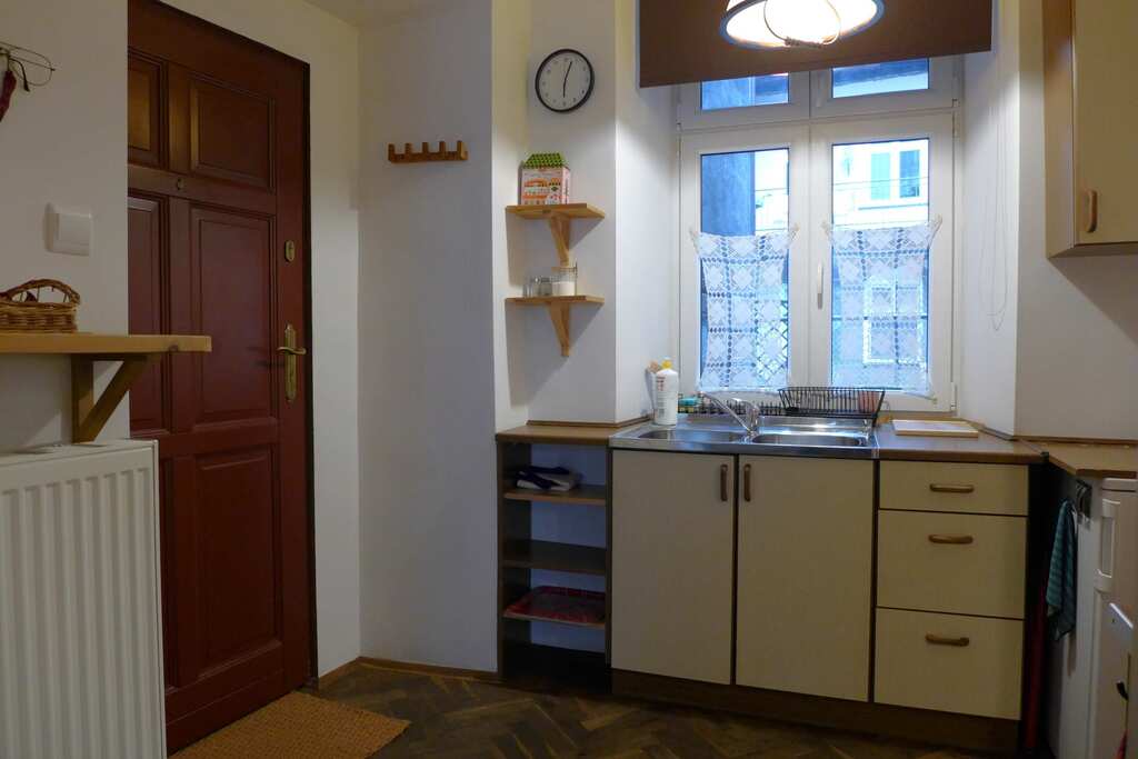 Widok na drzwi wejściowe i fragment aneksu kuchennego.