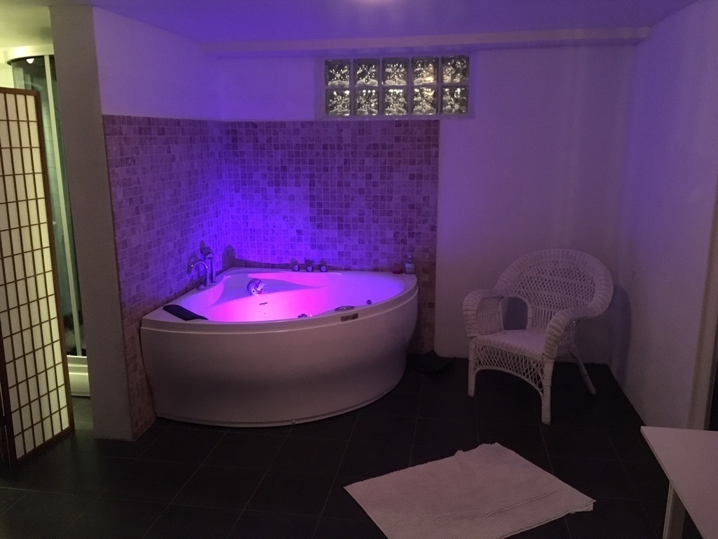 Downstairs a bathroom with a sauna and jacuzzi