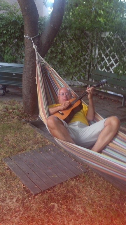 Jan play gitarr in our hamaca in our garden after work.