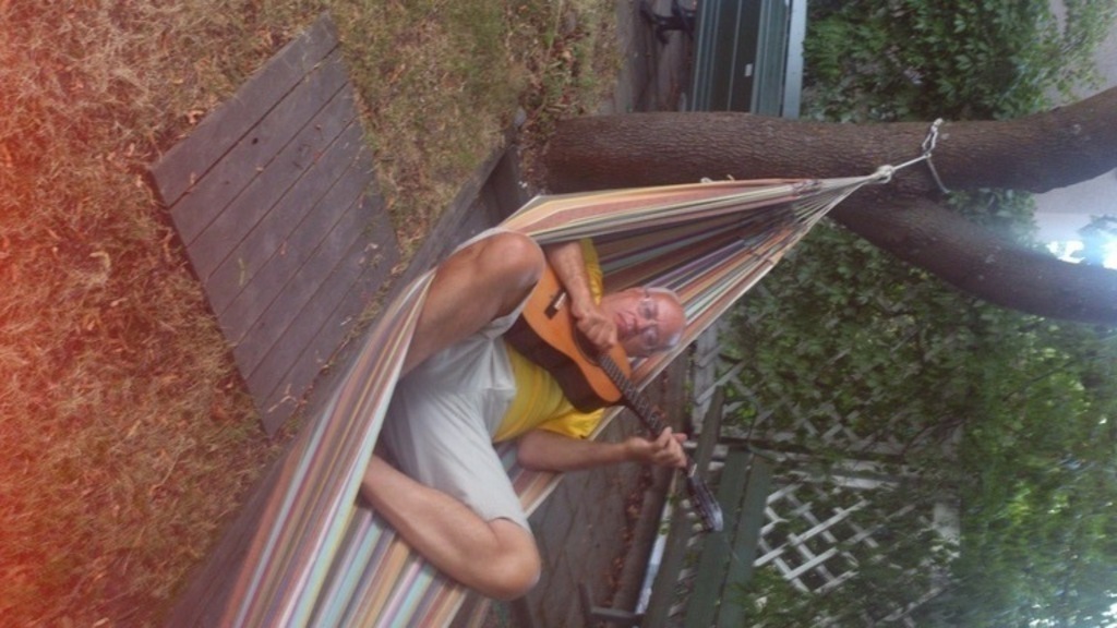 Jan play gitarr in our hamaca in our garden after work.