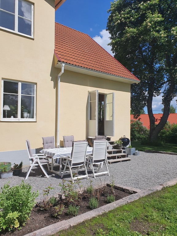 The sunny side of the garden with outdoor furniture and barbeque