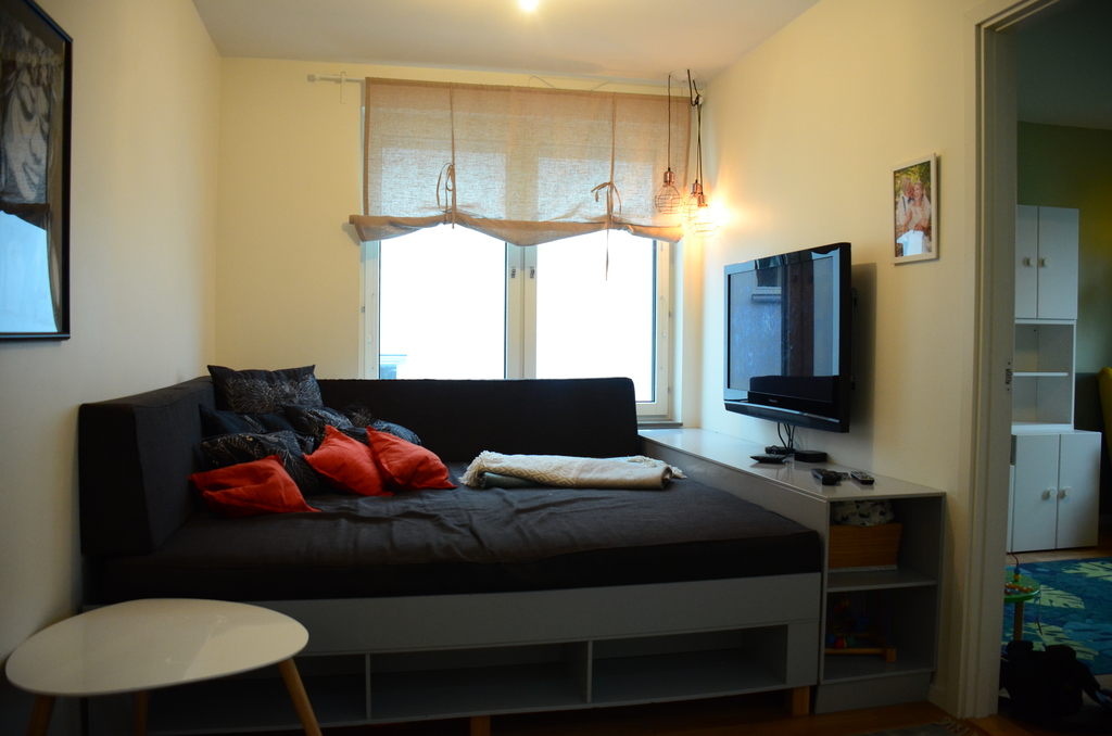 TV-area with large sofa that serves as an extra bed 
