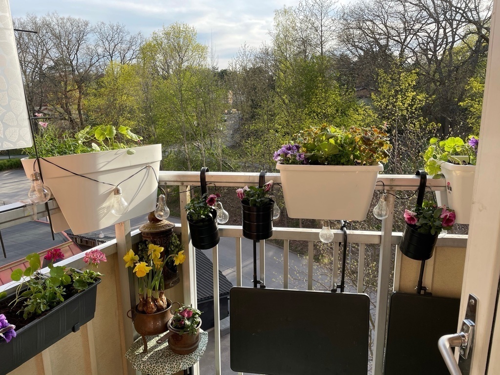 Solrig balkong med sit och matplats för två