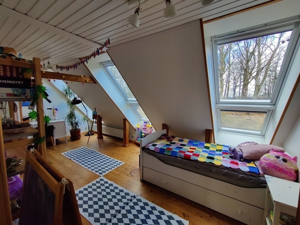 Large bedroom with a singel bed. Large windows with blackout curtains for blocking the light in the morning. 