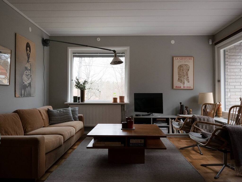 Vardagsrum med stor soffa, två fåtöljer och en 32" TV.