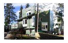 Wooden panel house, situated in hillock with small pine forest