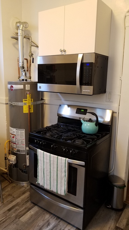 Gas water heater, gas stove, oven, and microwave in the kitchen.