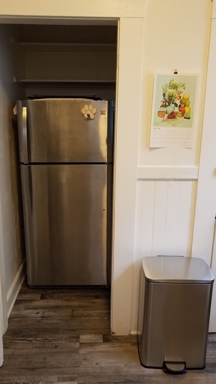 Refrigerator, freezer, and Lunar New Year calendar in the kitchen.