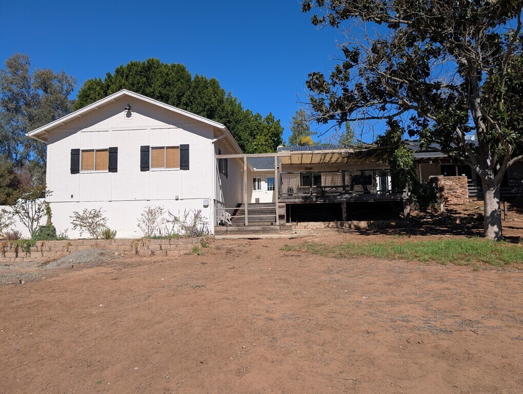 Front fenced yard with view of house.