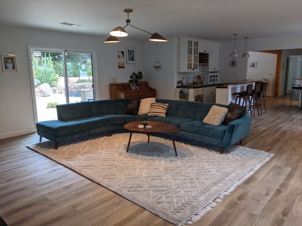 One of three living spaces with large TV, piano, and fireplace.