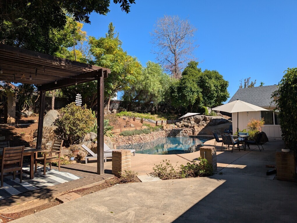 Backyard with view of pool. Two dining sets.