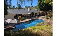 Pool yard with hot tub.