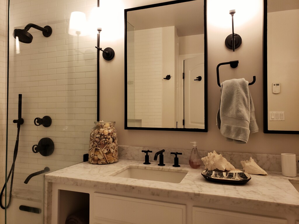 lower level master bathroom with double sinks and shower tub