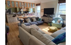 Sundrenched living room with two comfortable couches and reading chair.