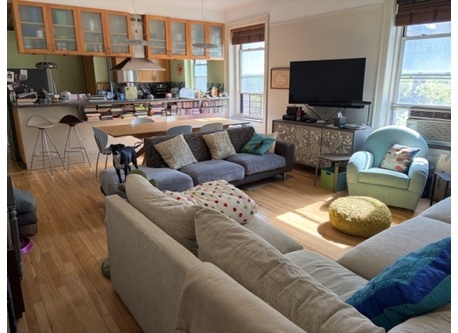 Sundrenched living room with two comfortable couches and reading chair.