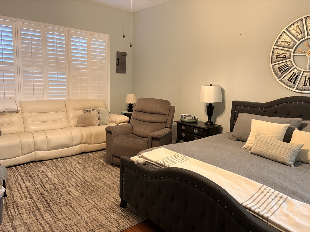 Master bedroom with sofa and recliner facing TV.