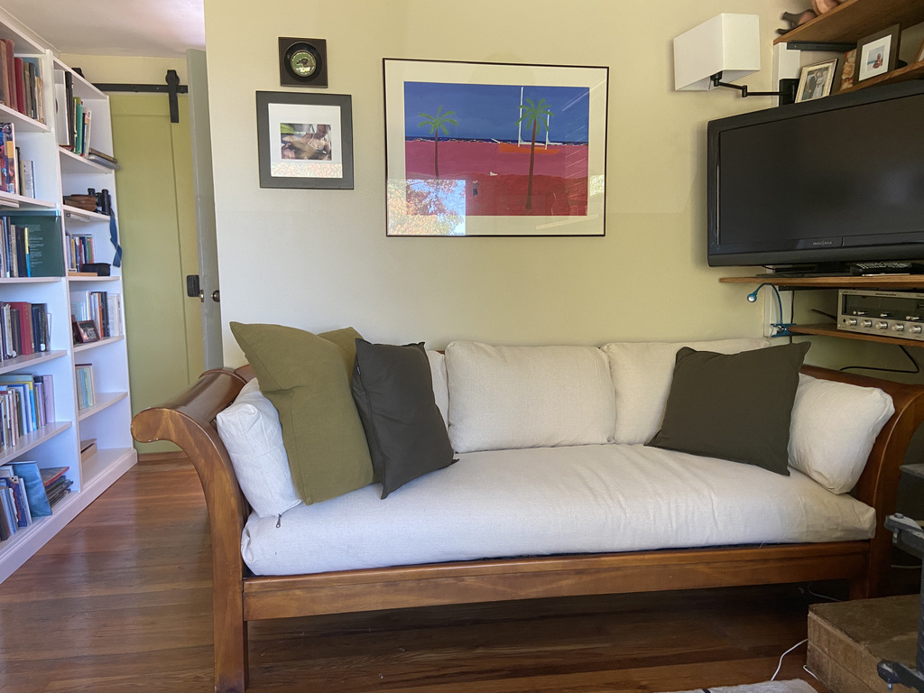 The downstairs living room with the bathroom around the corner. A sliding door leads into the small office beyond the bookcase. 
