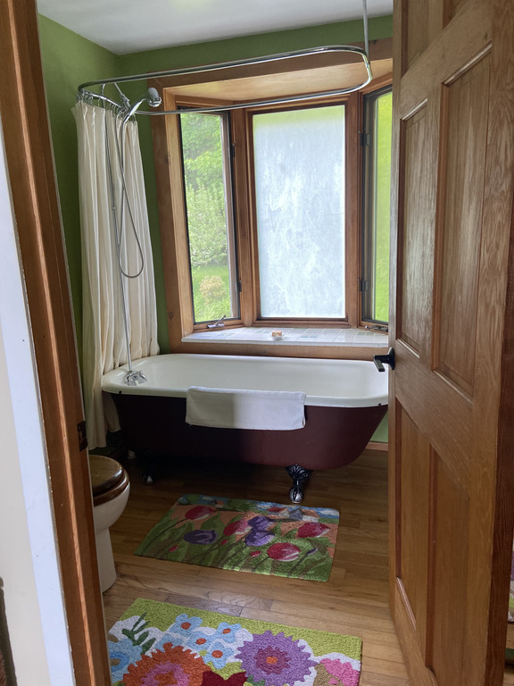 Upstairs bathroom with an old fashioned claw foot tub which also has shower capabilities. . 