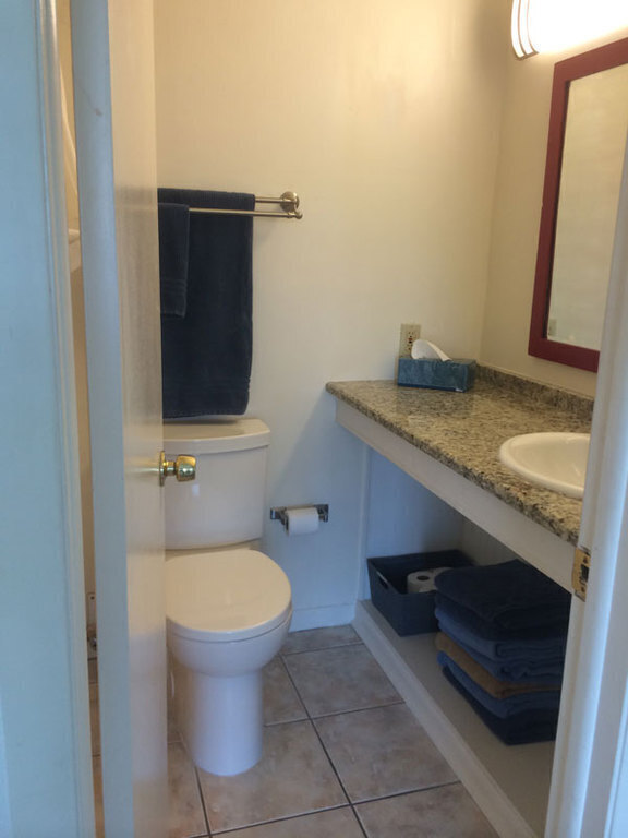 Ensuite bathroom for twin bed bedroom. Tub with shower behind door.